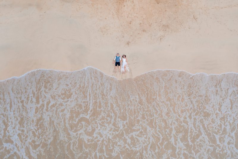Arial photo of bride and groom lying on Las Terrenas beach