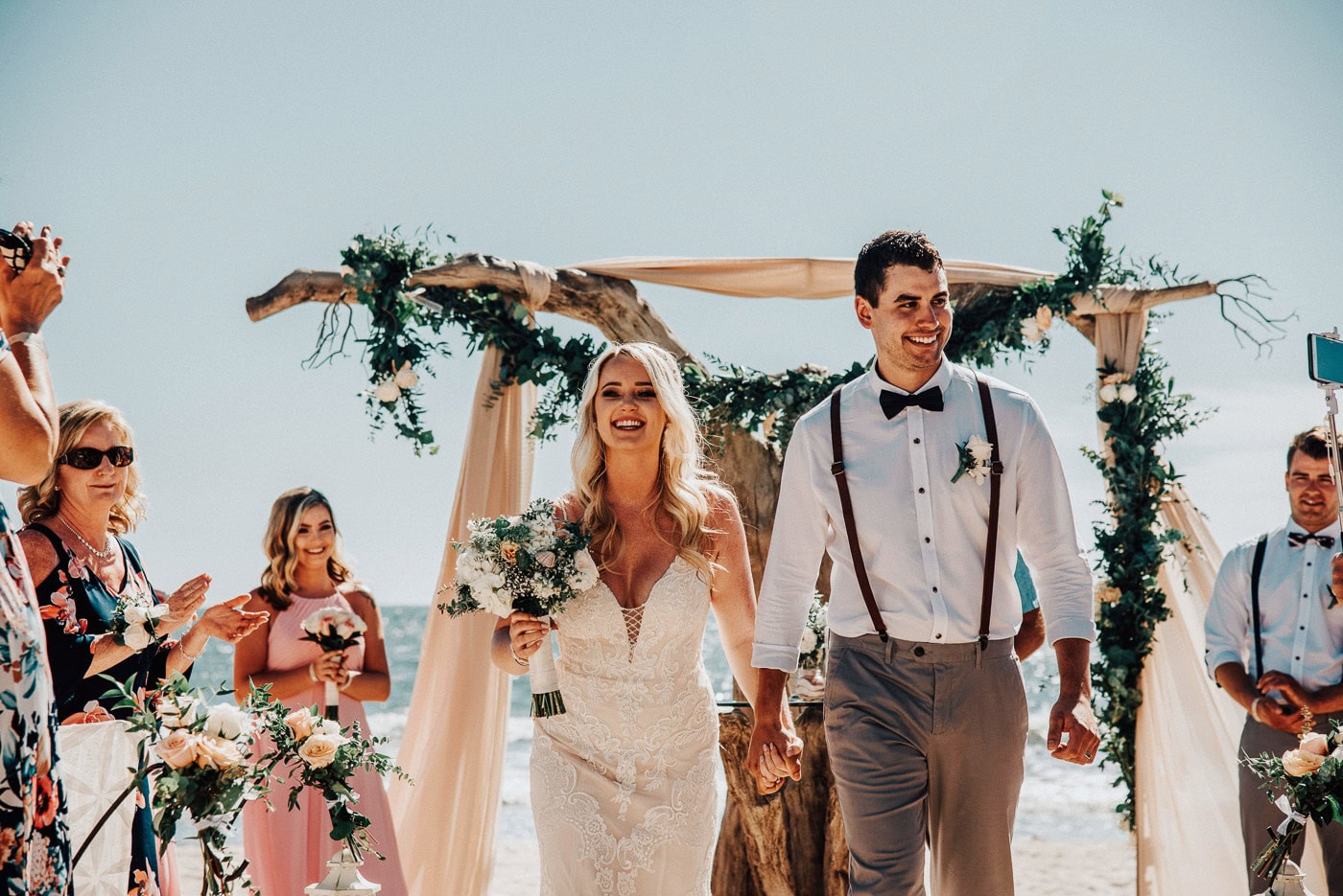 post ceremony, married couple walking back down the aisle, happy and smiling