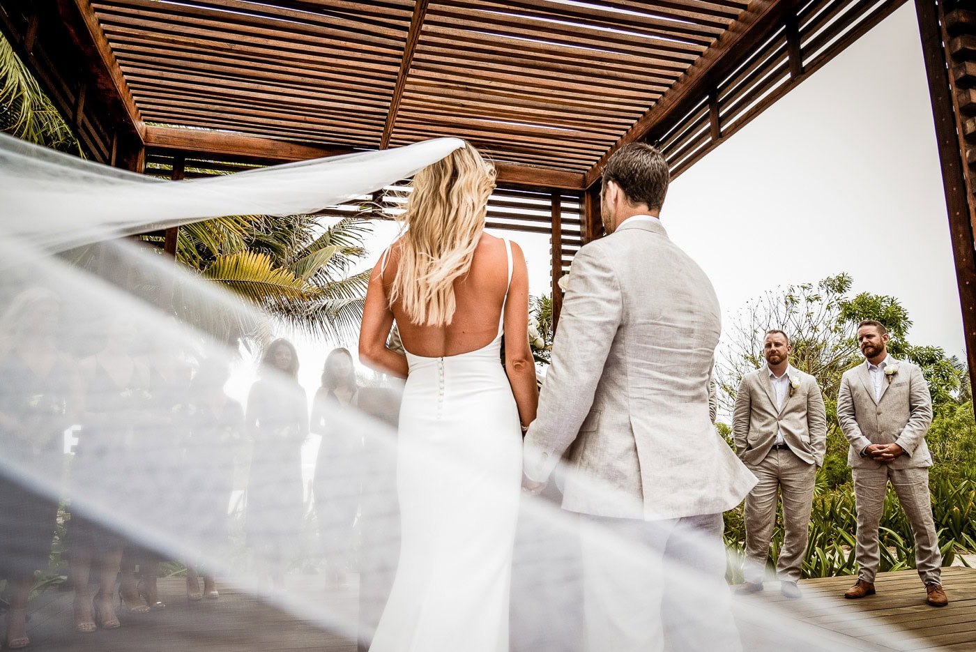 bride and groom standing before their wedding party after exchaning vows 