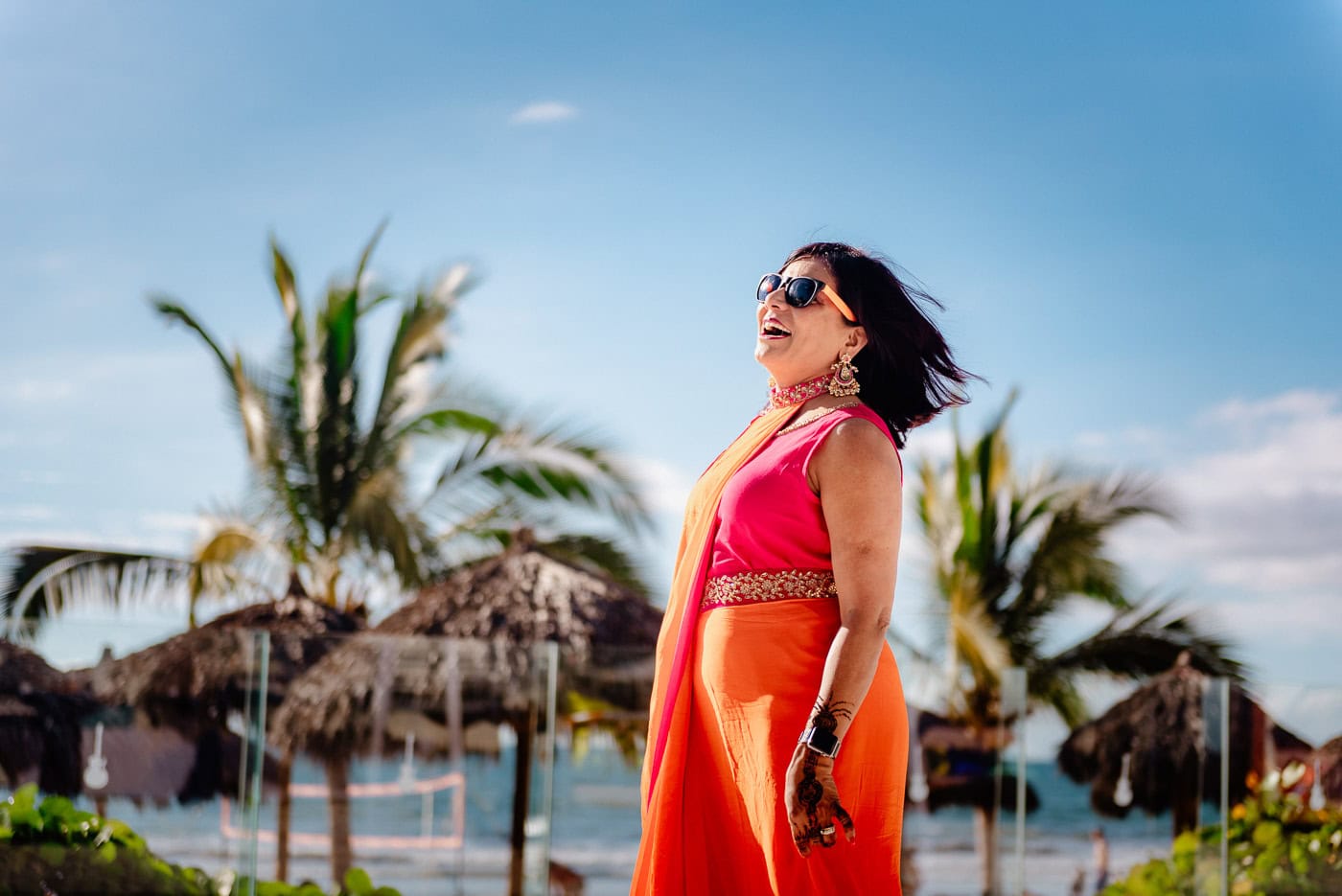woman in beach wedding outfit wearing sunglasses on a tropical shore