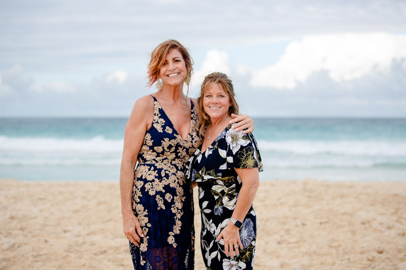 wedding guests in bohemian wedding dresses standing on the beach
