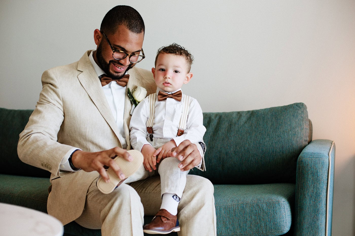 groom and ring bearer in cream linen suits before the wedding