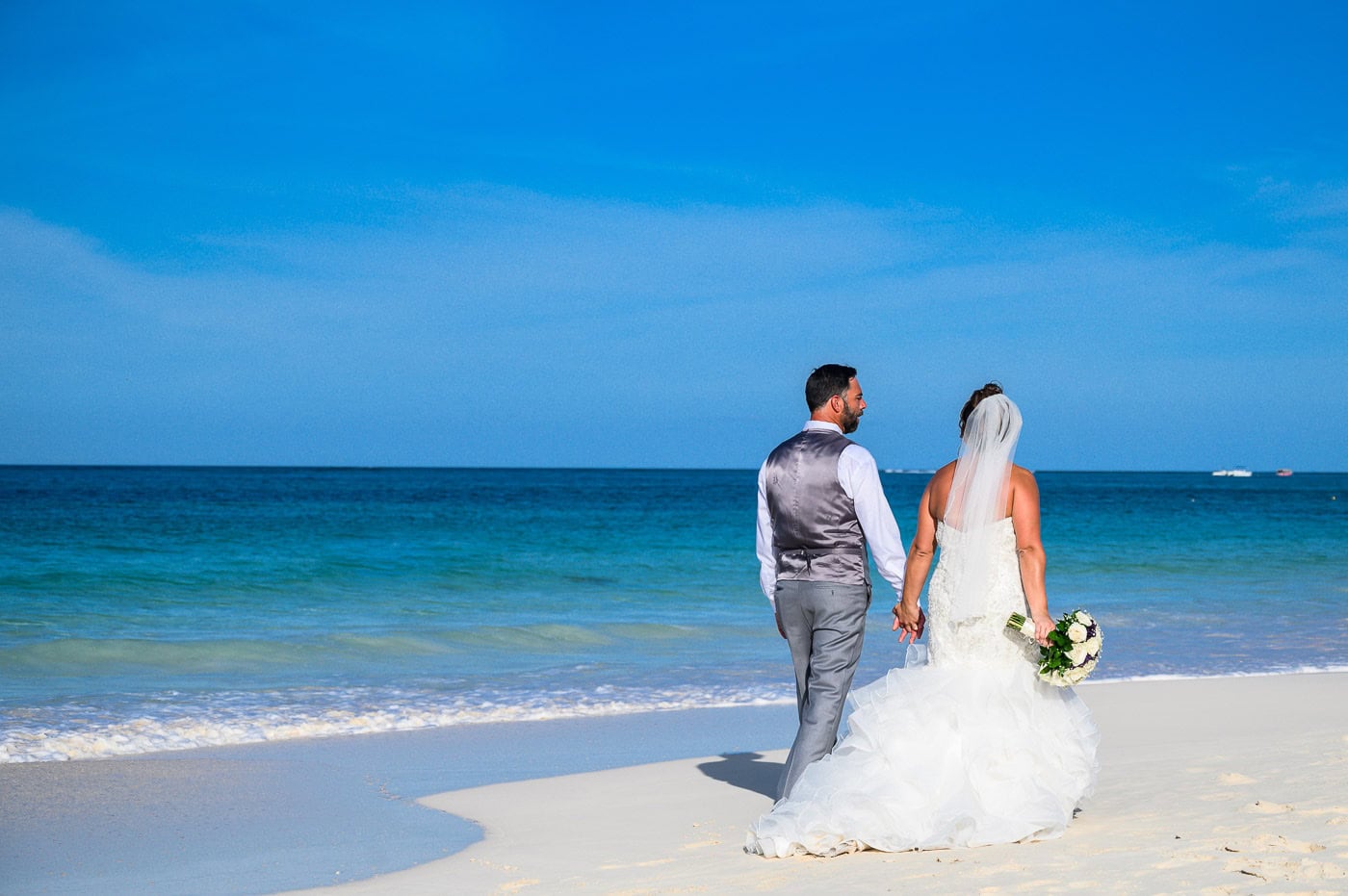 bride and groom walking in bavaro beach