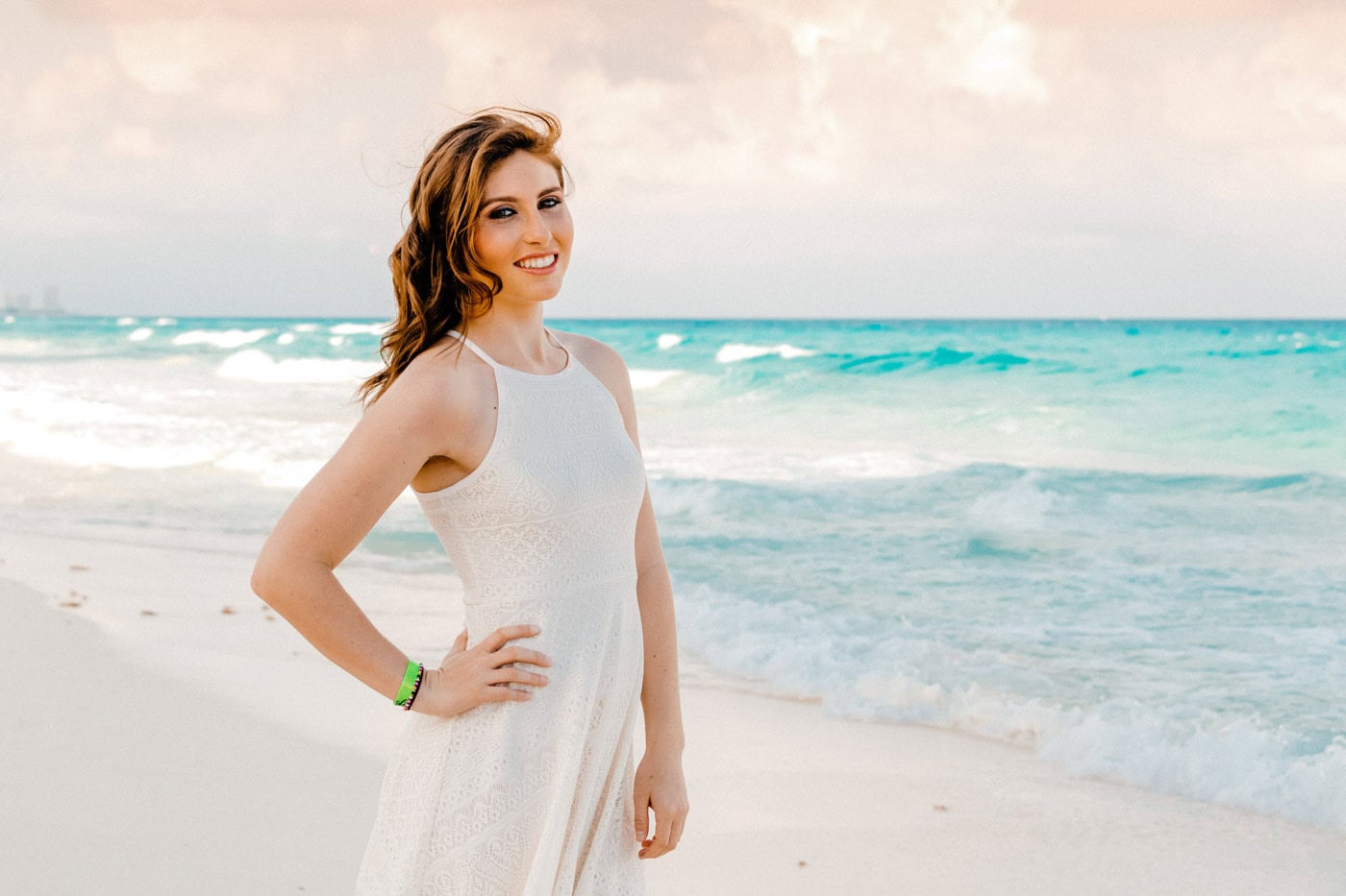 Bride in a flowing white dress posing on the beach during a Punta Cana destination wedding photo session