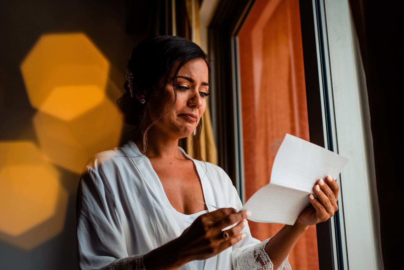 Bride in her robe reading her wedding vows with emotion before the ceremony