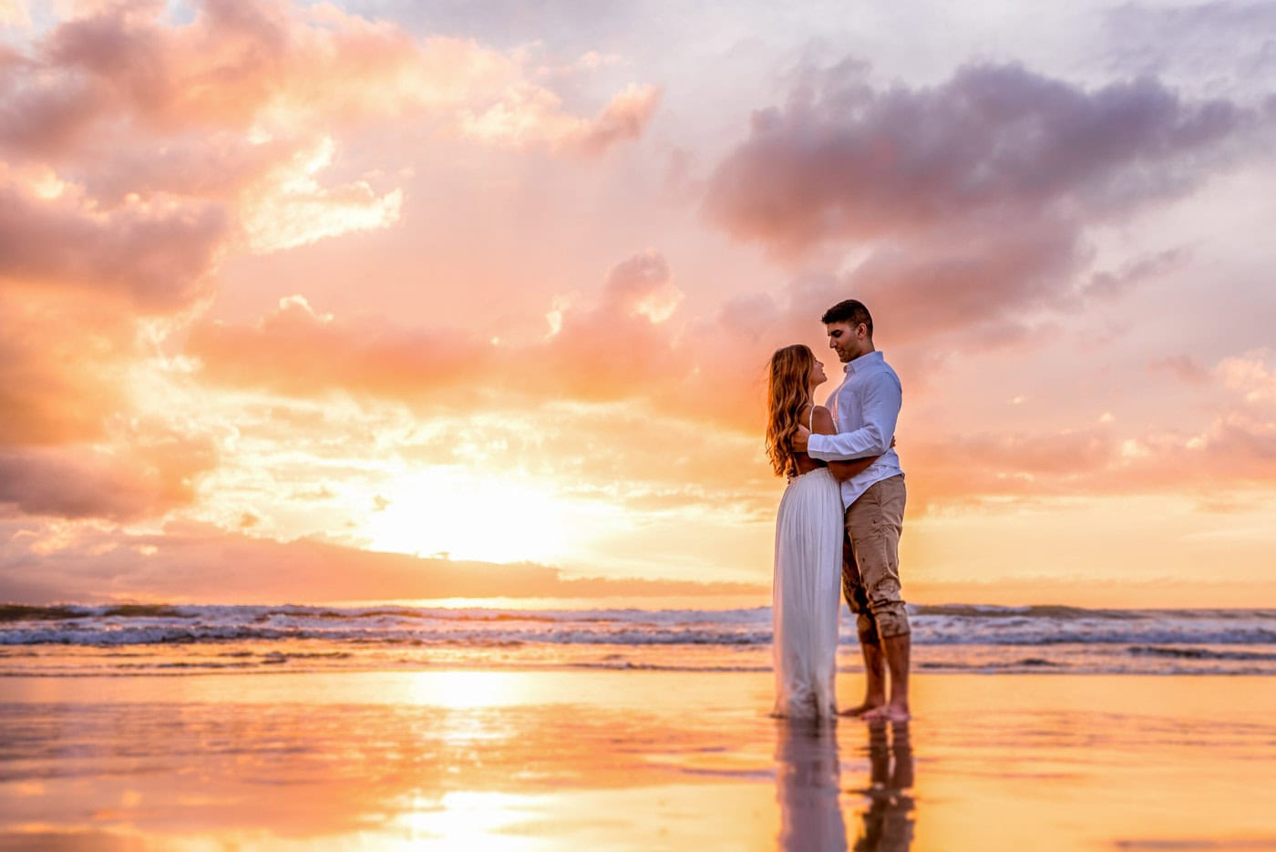 Romantic couple embracing at sunset on the beach.