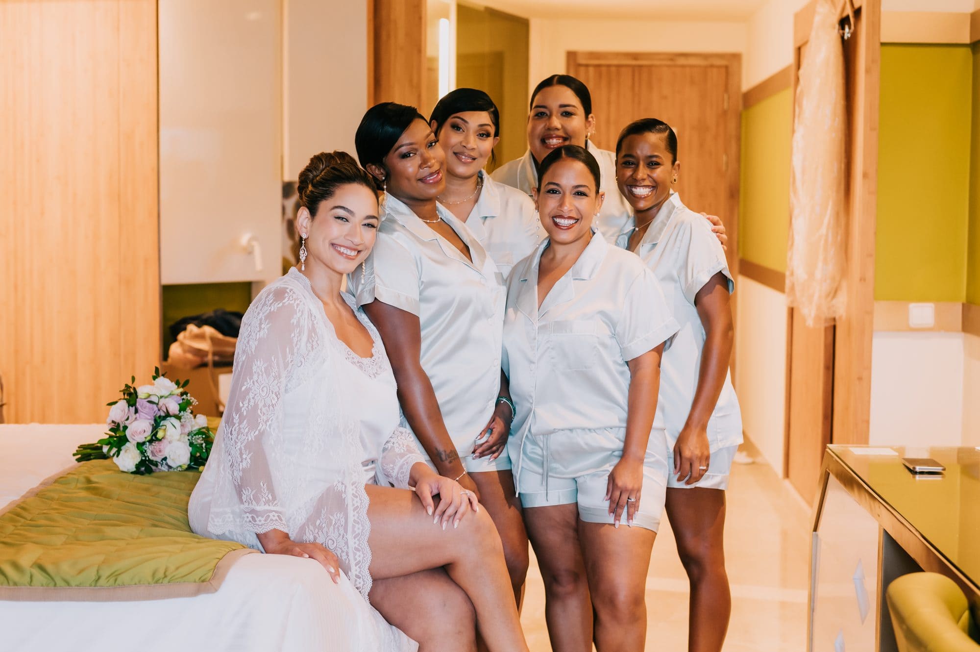 Bride with her bridesmaids in matching satin pajamas before a Dreams Onyx destination wedding