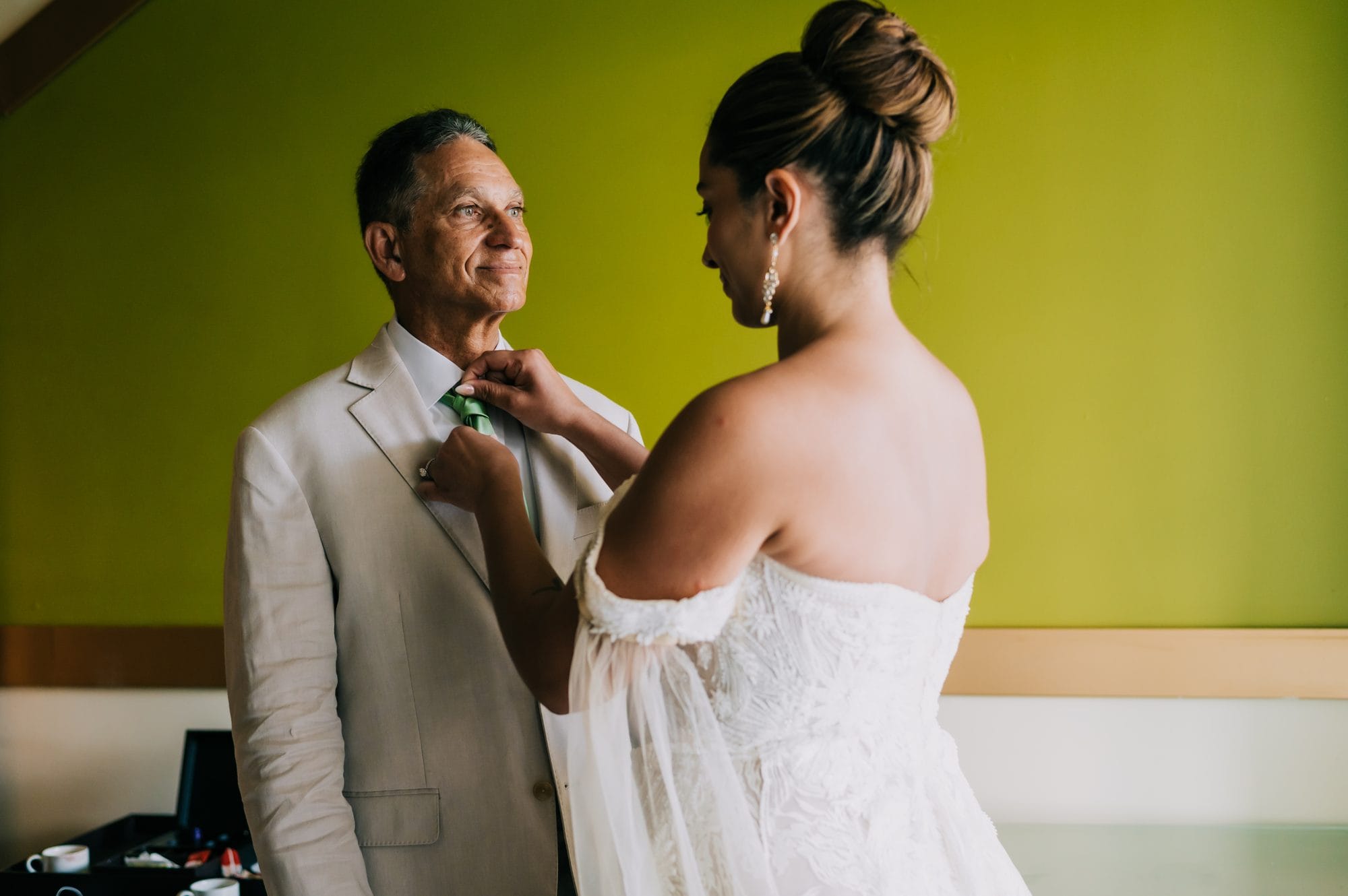 Bride fixing her father’s green tie before walking down the aisle in Punta Cana