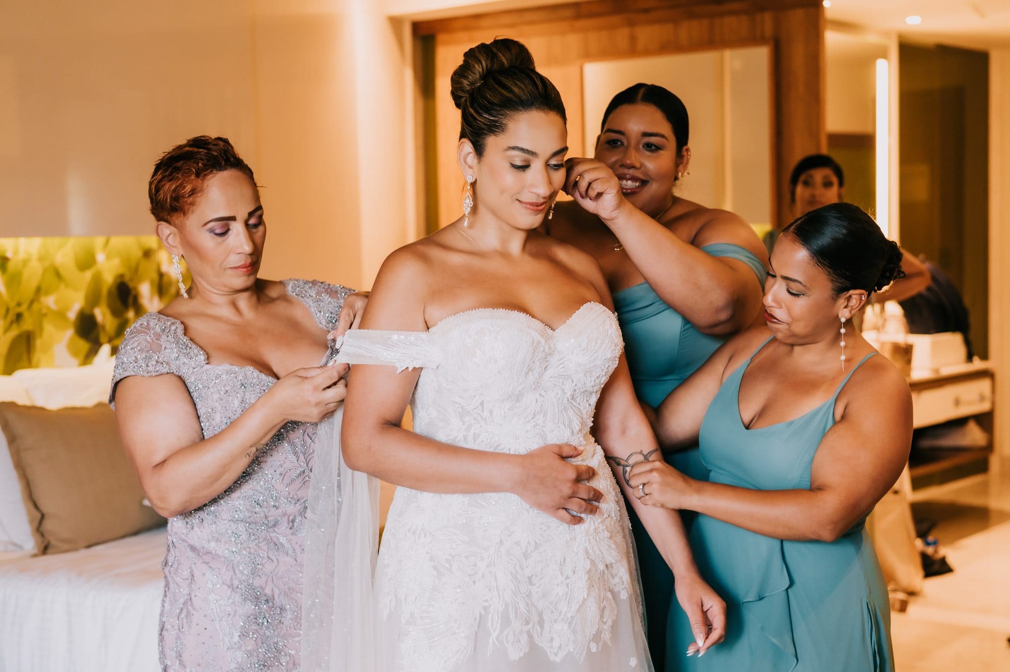 Bride’s mother and bridesmaids helping her into her lace gown at Dreams Onyx Punta Cana