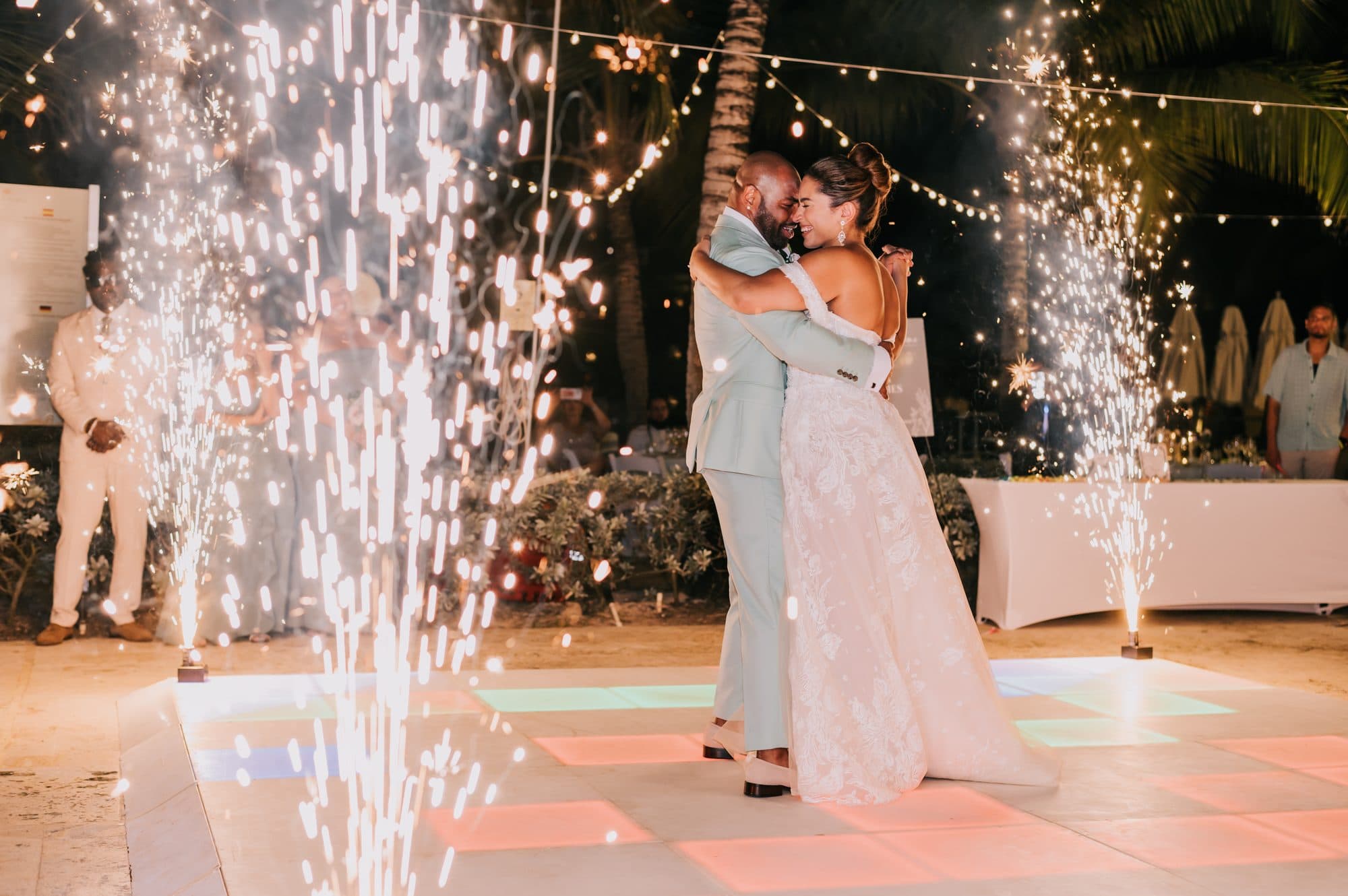 Newlyweds forehead to forehead during their first dance under string lights at Dreams Onyx Punta Cana