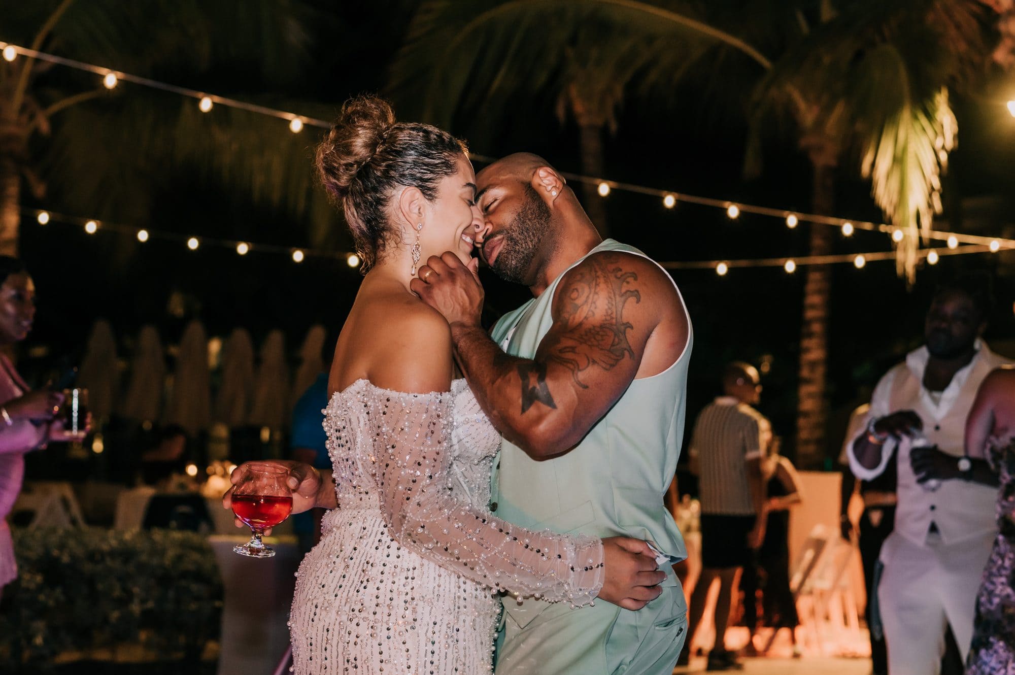 Bride and groom sharing a close slow dance under string lights at their Punta Cana beach reception