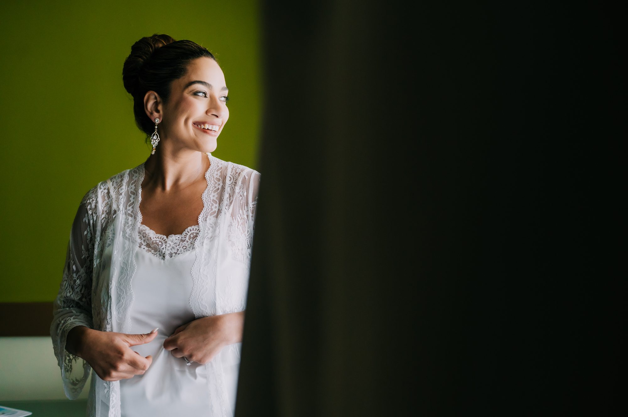 Smiling bride in a lace robe on her wedding morning in Punta Cana