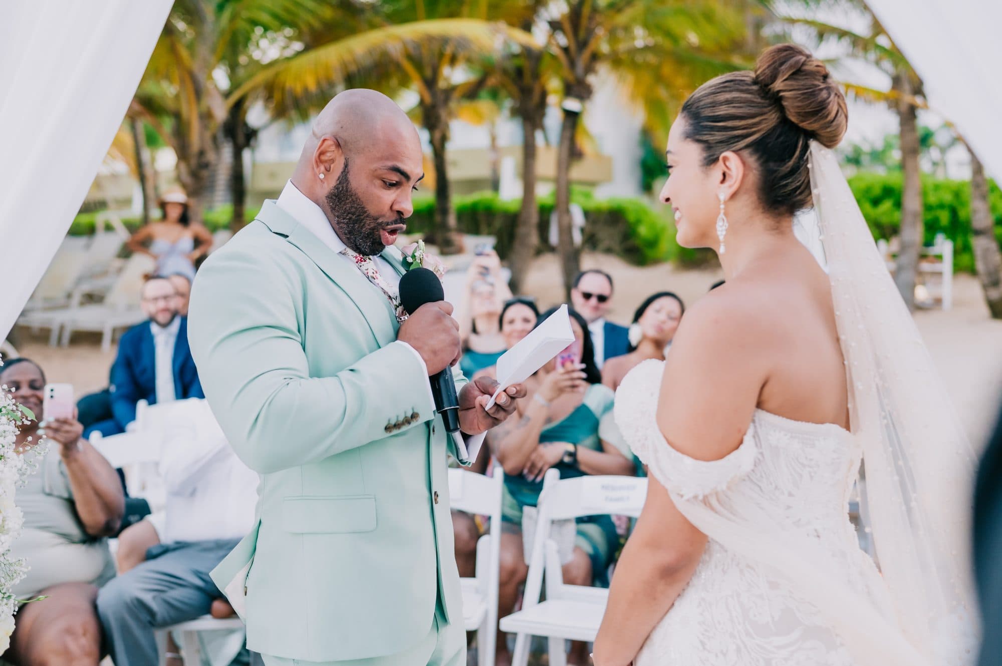 Groom reading his vows aloud to the bride during a Dreams Onyx beach wedding in Punta Cana