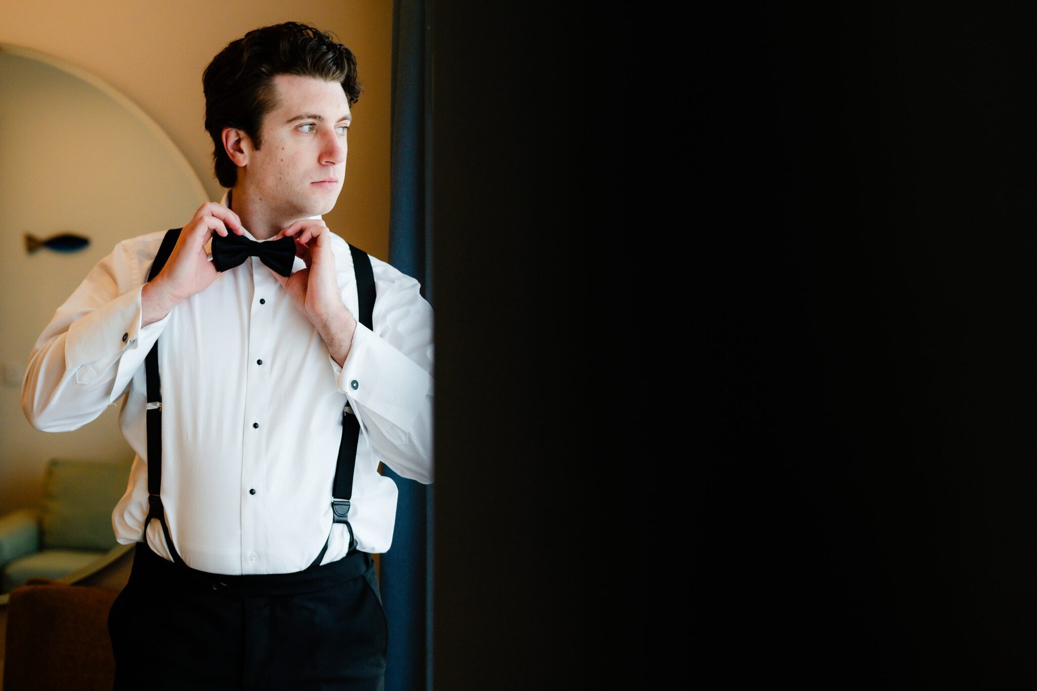 Groom adjusting his bow tie while getting ready for his Punta Cana wedding