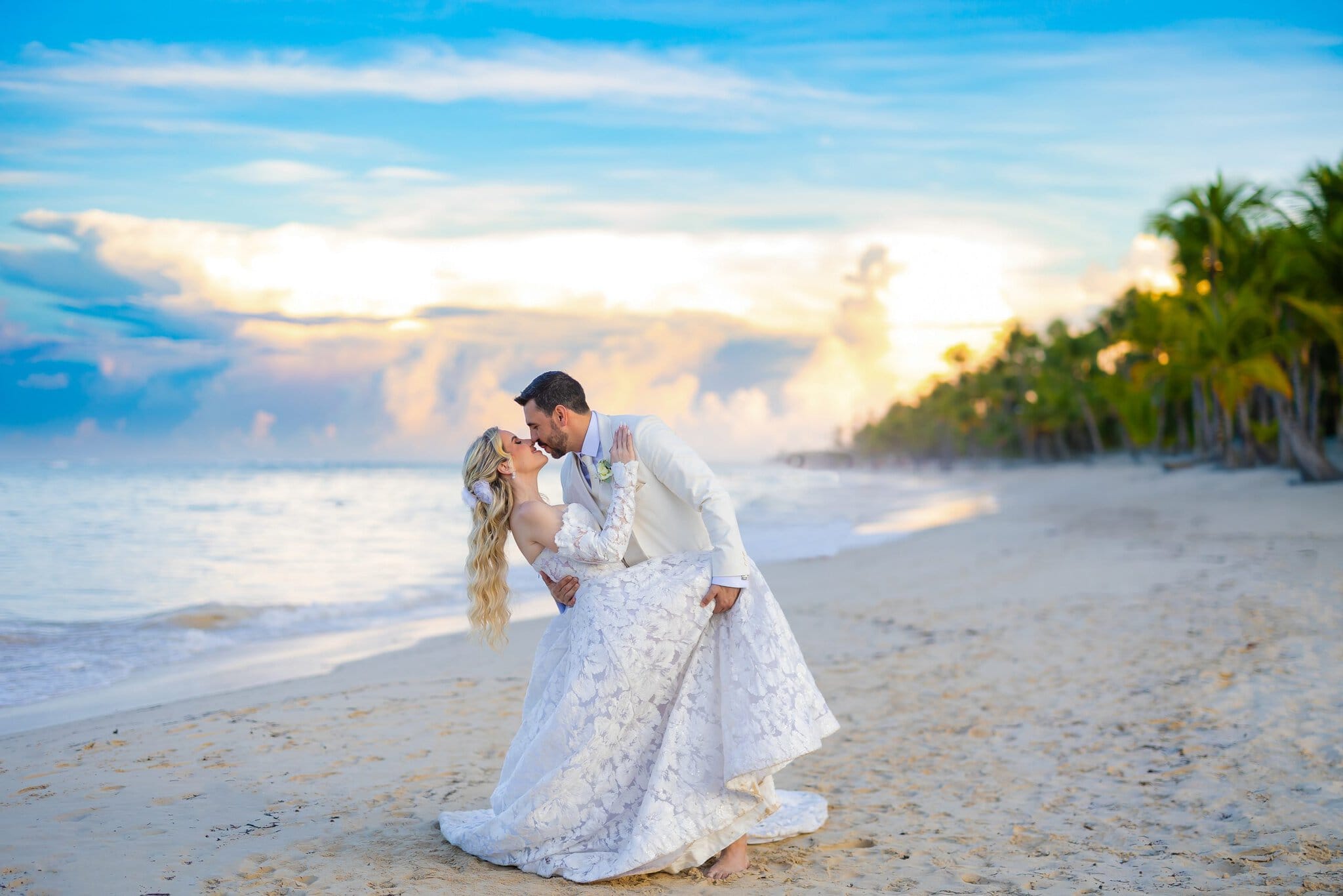 Groom dipping bride for a kiss at sunset on a Punta Cana beach