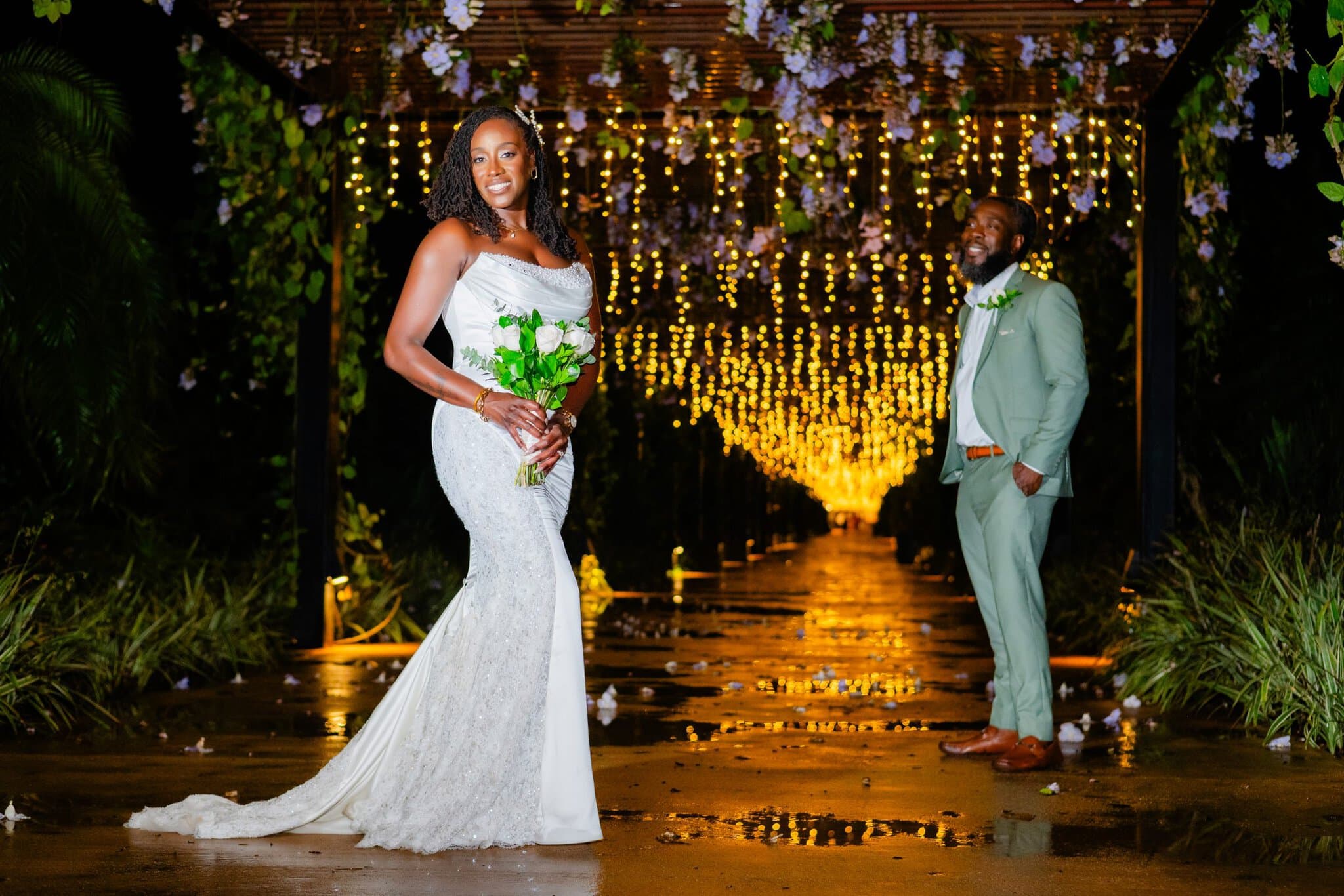 Bride and groom night portrait under a tunnel of fairy lights at a Punta Cana resort