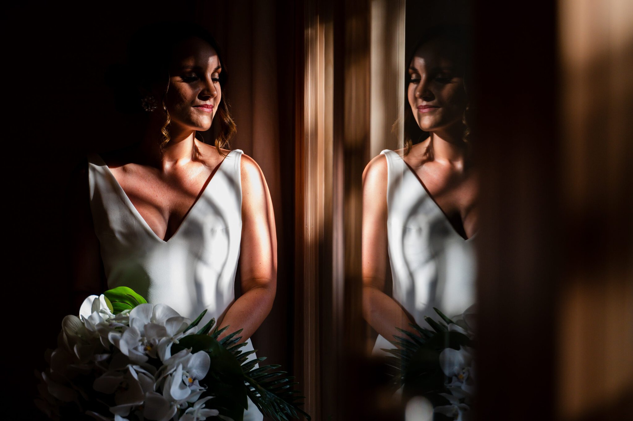 Dramatic bridal portrait with window light and mirror reflection at a Punta Cana wedding