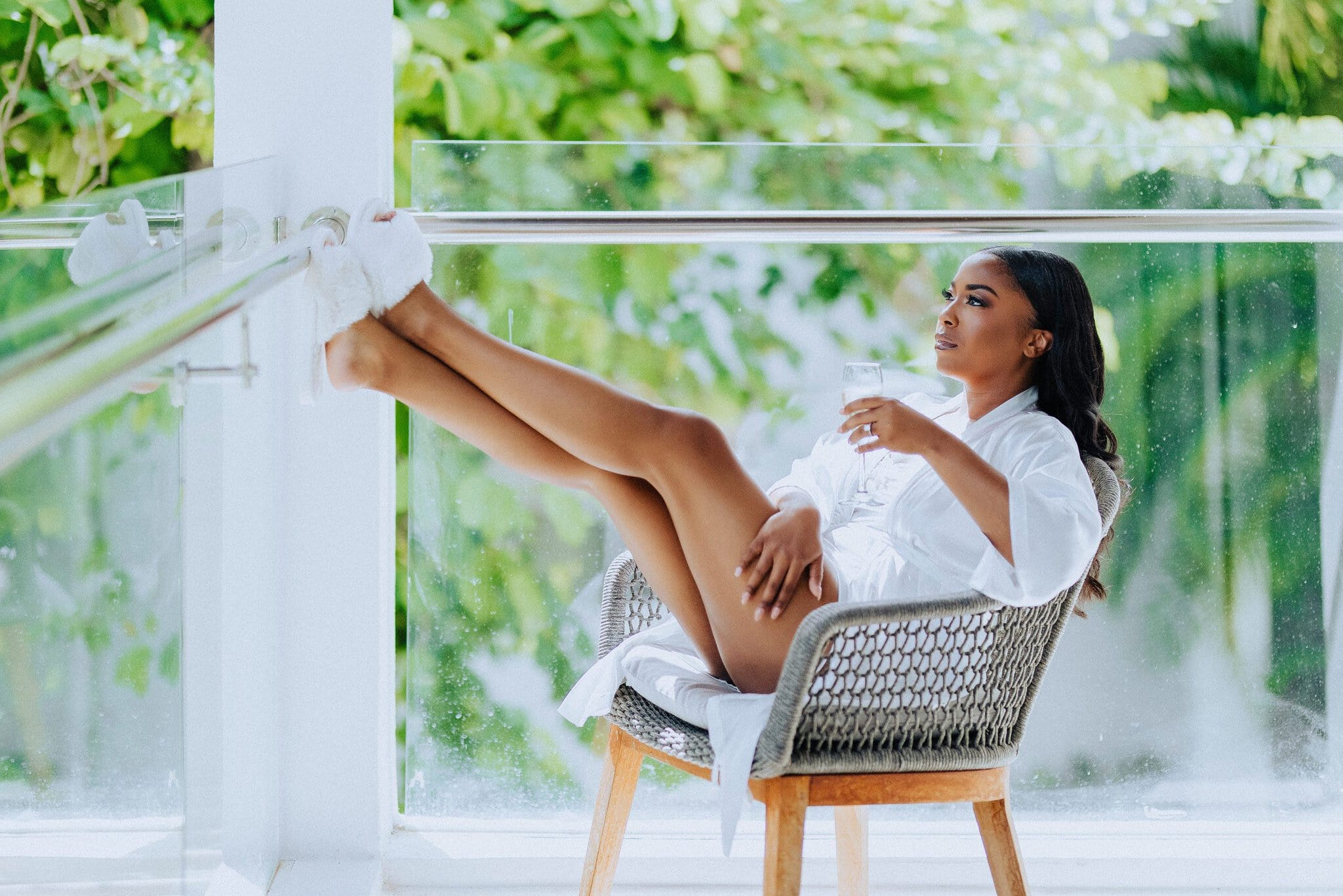 Relaxed bride with a glass of champagne while getting ready for her Punta Cana wedding