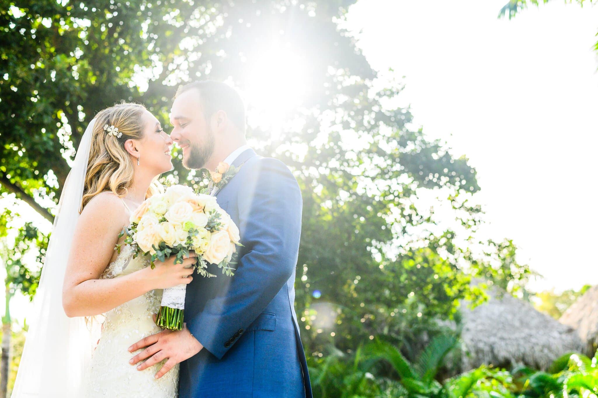 Couple kissing in sunlit garden light at a Punta Cana wedding