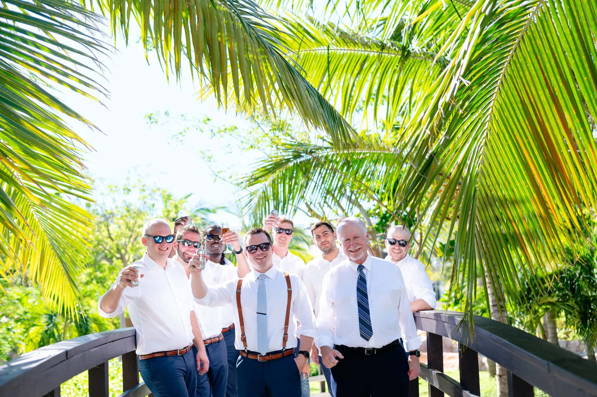 Groomsmen raising a relaxed toast under the palms at a Punta Cana wedding