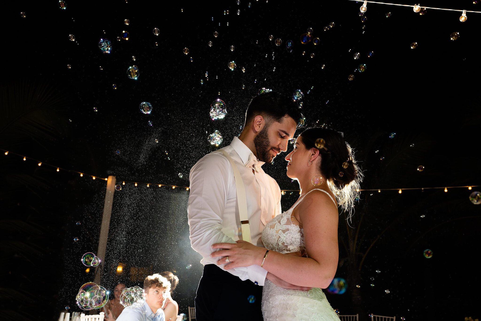 A newlywed couple share their first dance among floating bubbles at their Punta Cana wedding reception.