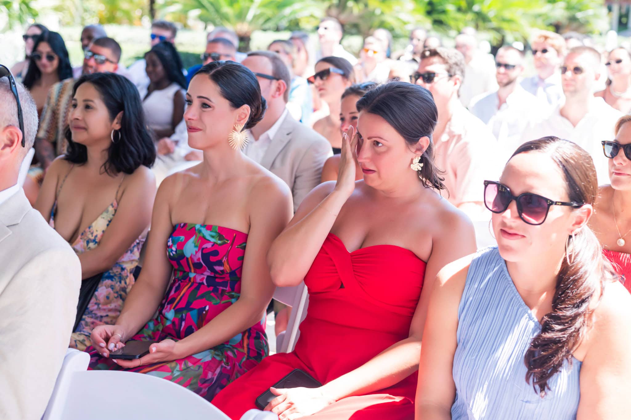 Wedding guests watching the resort ceremony from the front rows, including one guest wiping away a tear.