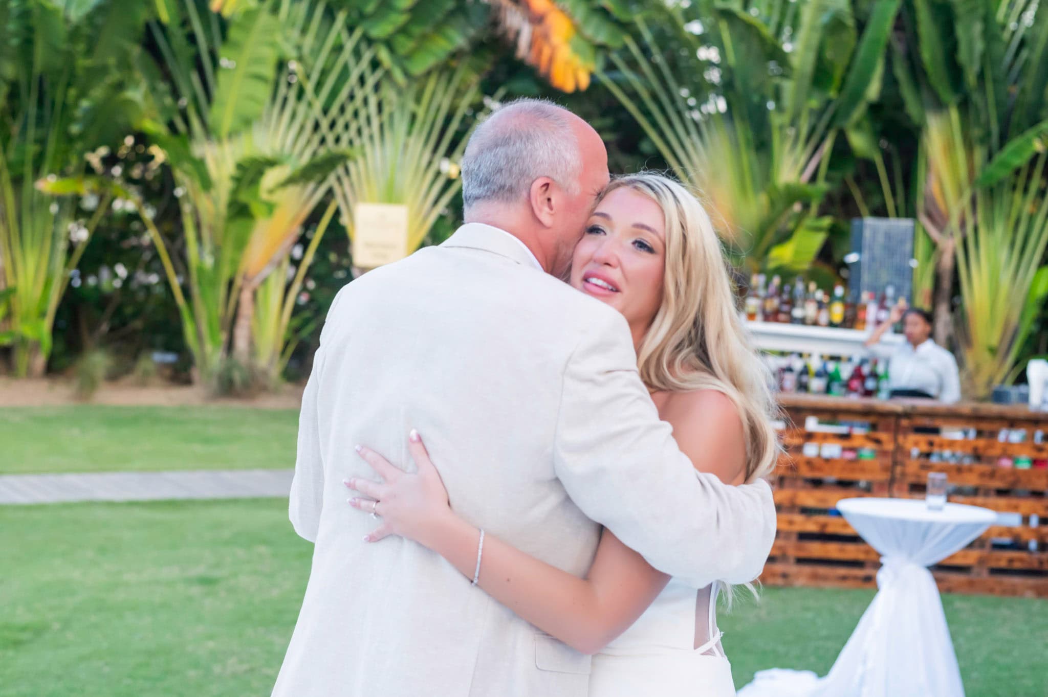 Bride embracing her father during a family dance at the outdoor reception.