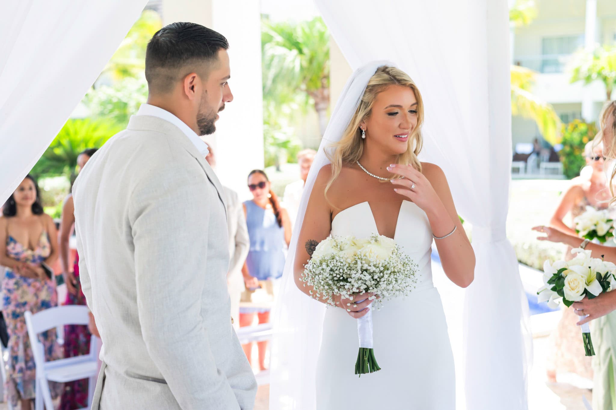 Close view of the bride smiling at the groom while holding her bouquet during the ceremony.