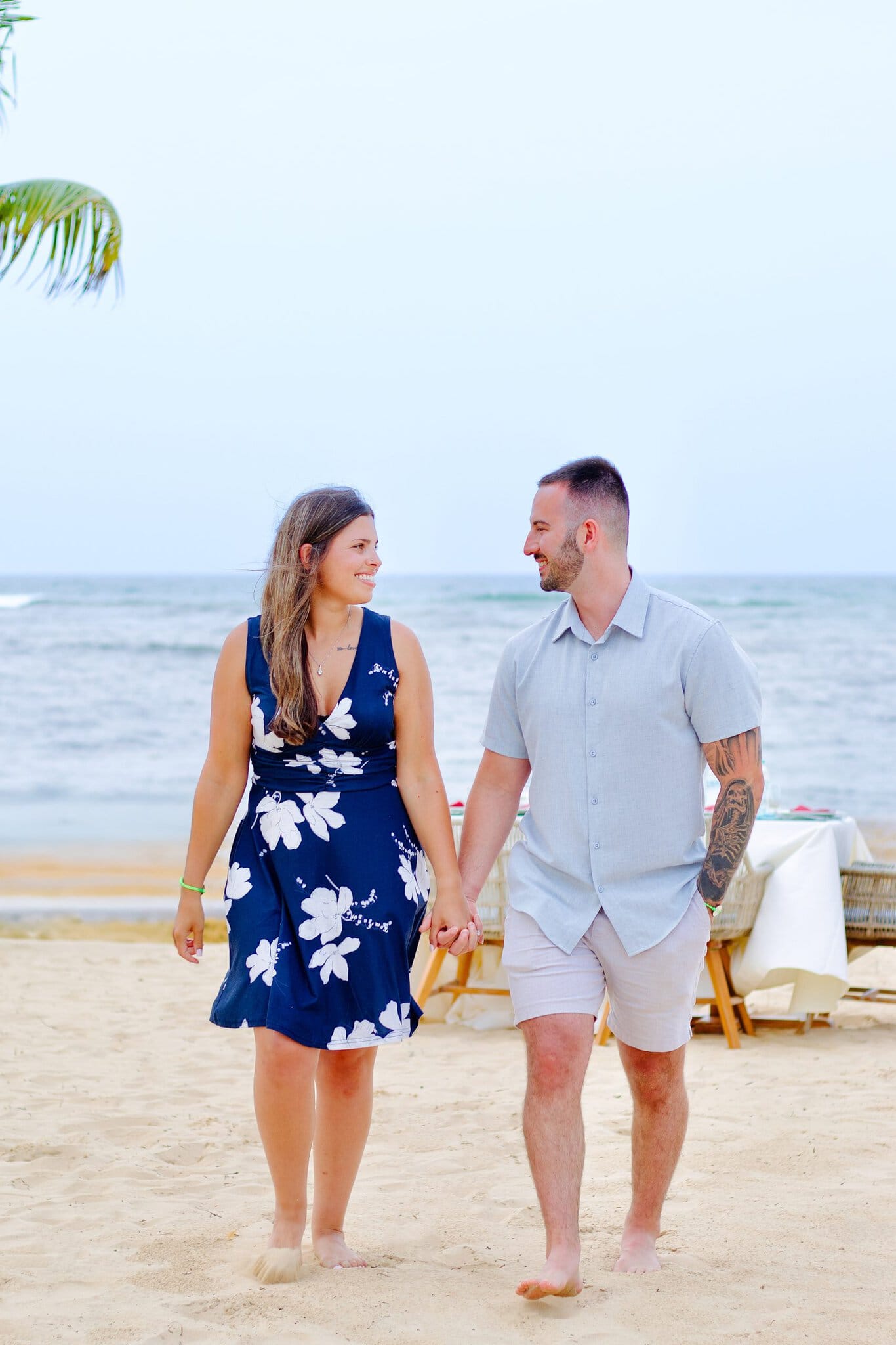 Newly engaged couple walking hand in hand along a quiet Punta Cana shoreline