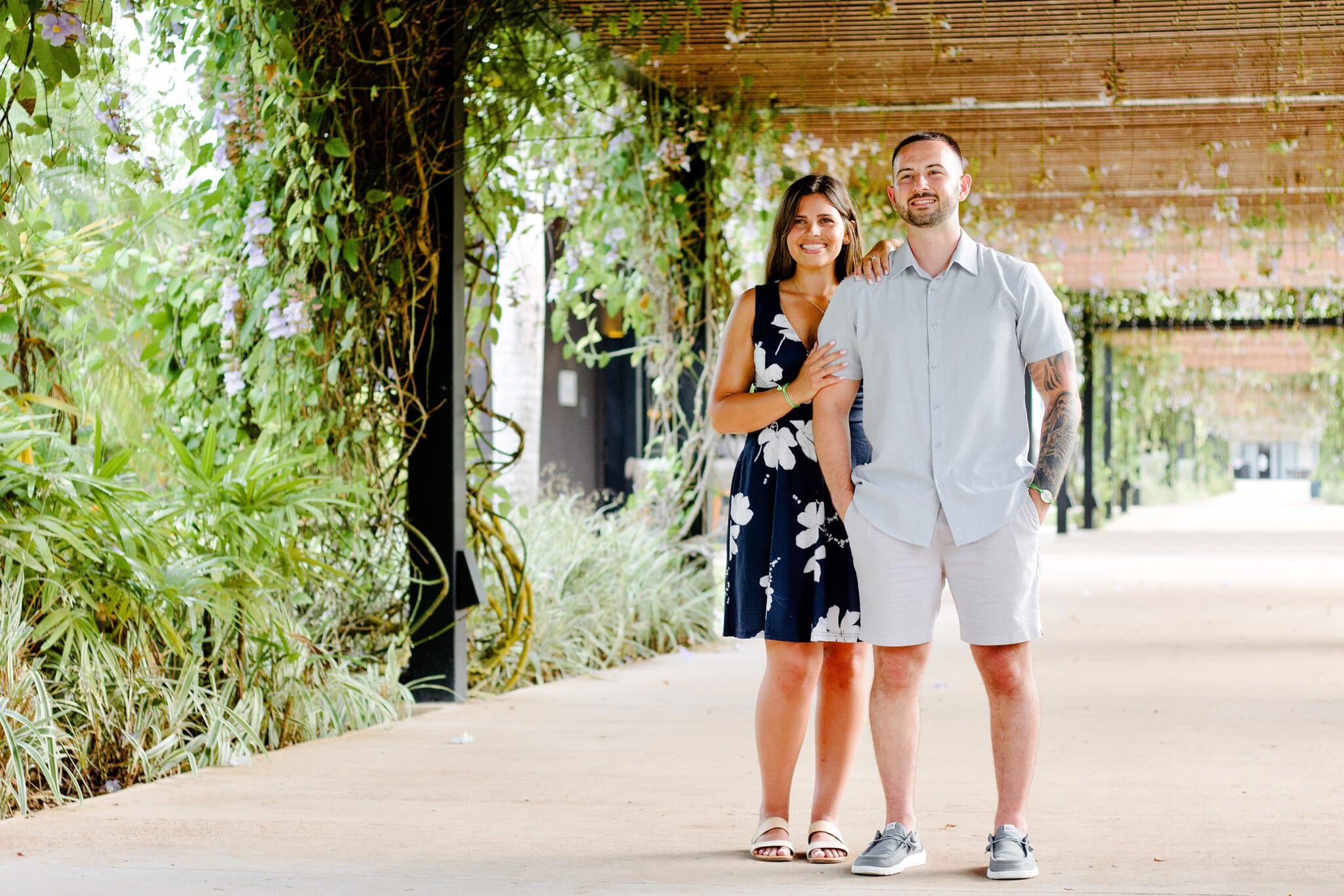 Full-length portrait of a newly engaged couple under a garden pergola at Live Aqua Punta Cana
