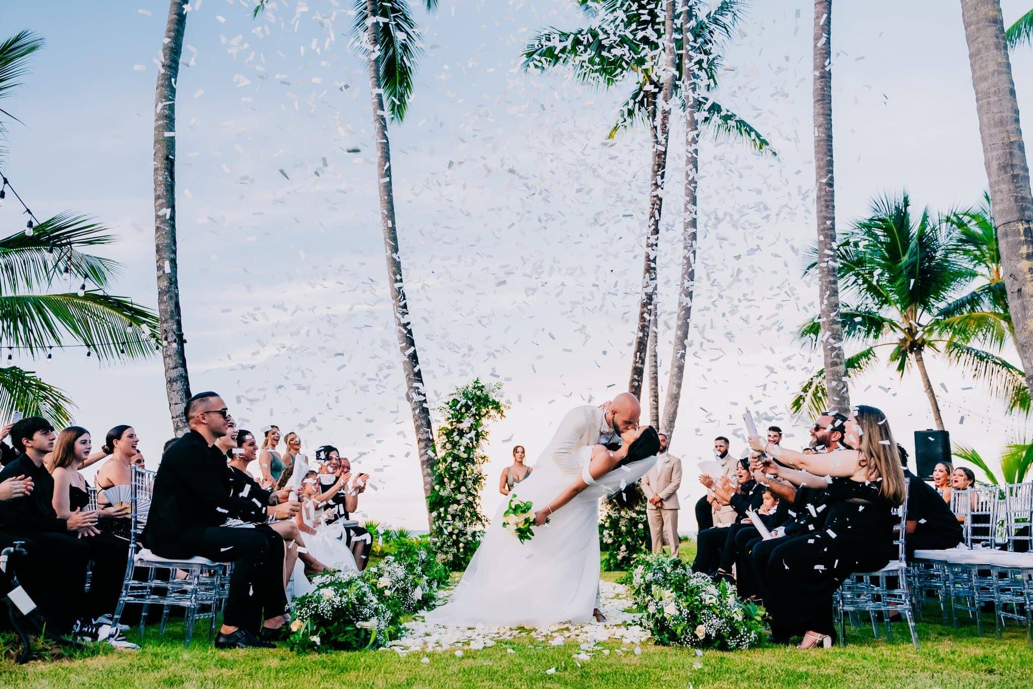 Newlyweds celebrating under a shower of confetti at a Dominican Republic beach wedding