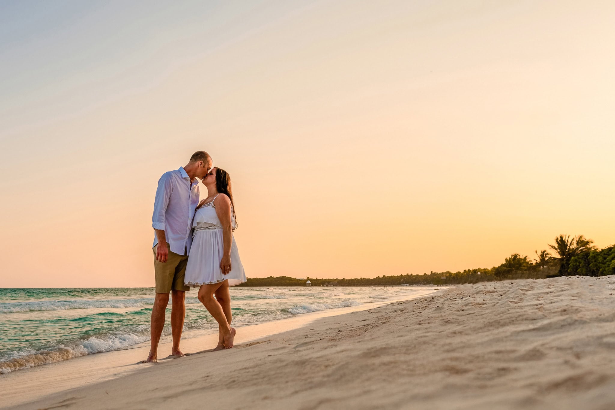 Couple kissing on the beach at sunset during an engagement session in Punta Cana