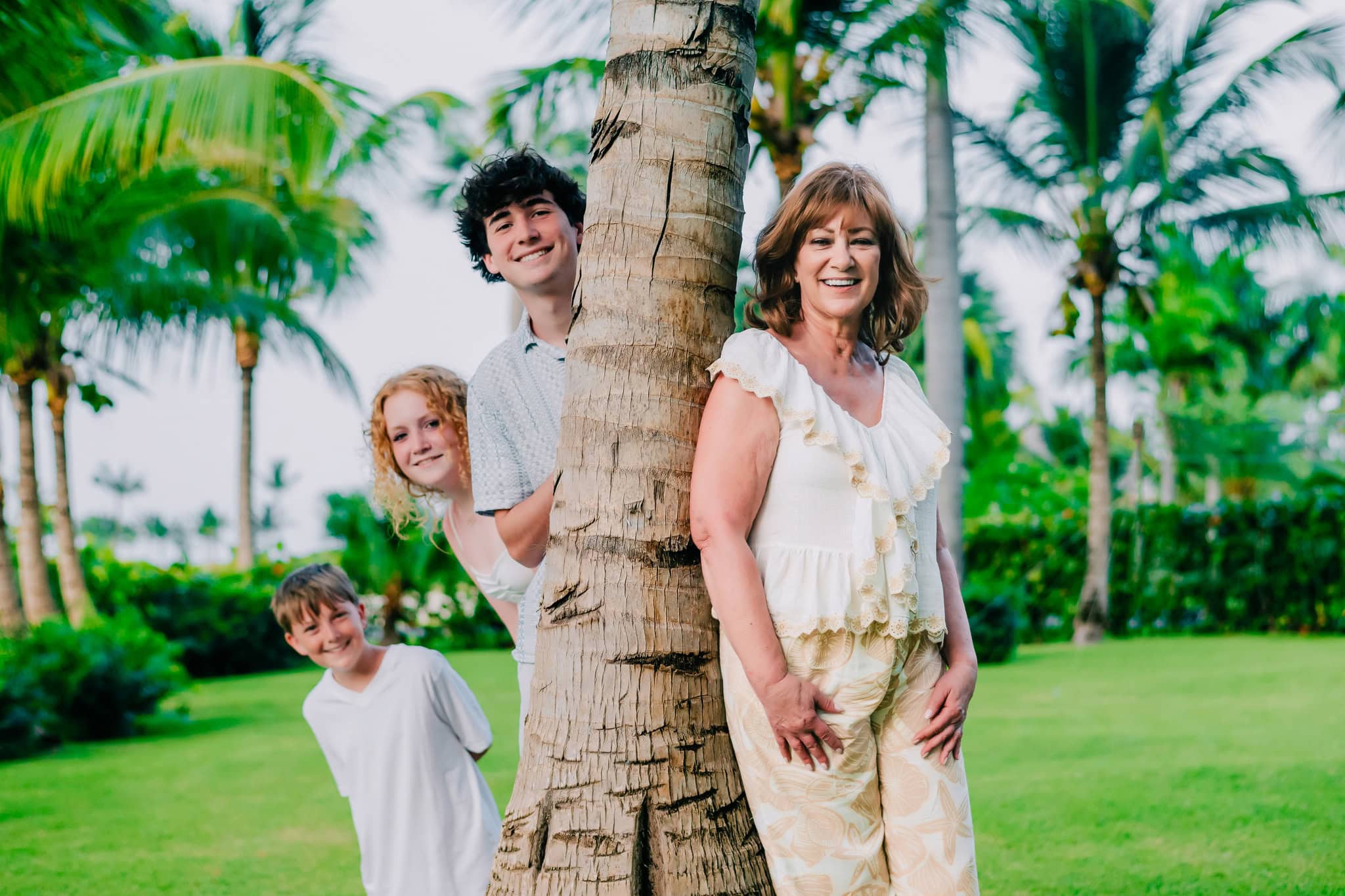 Family of four crouching on the sand during a beach photo session in Punta Cana