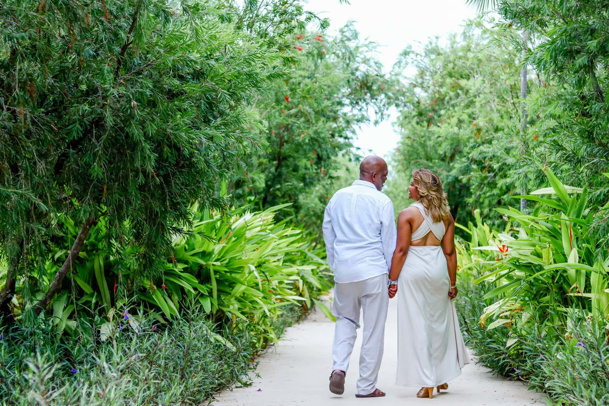 Couple holding hands and walking through the tropical gardens at Live Aqua Punta Cana