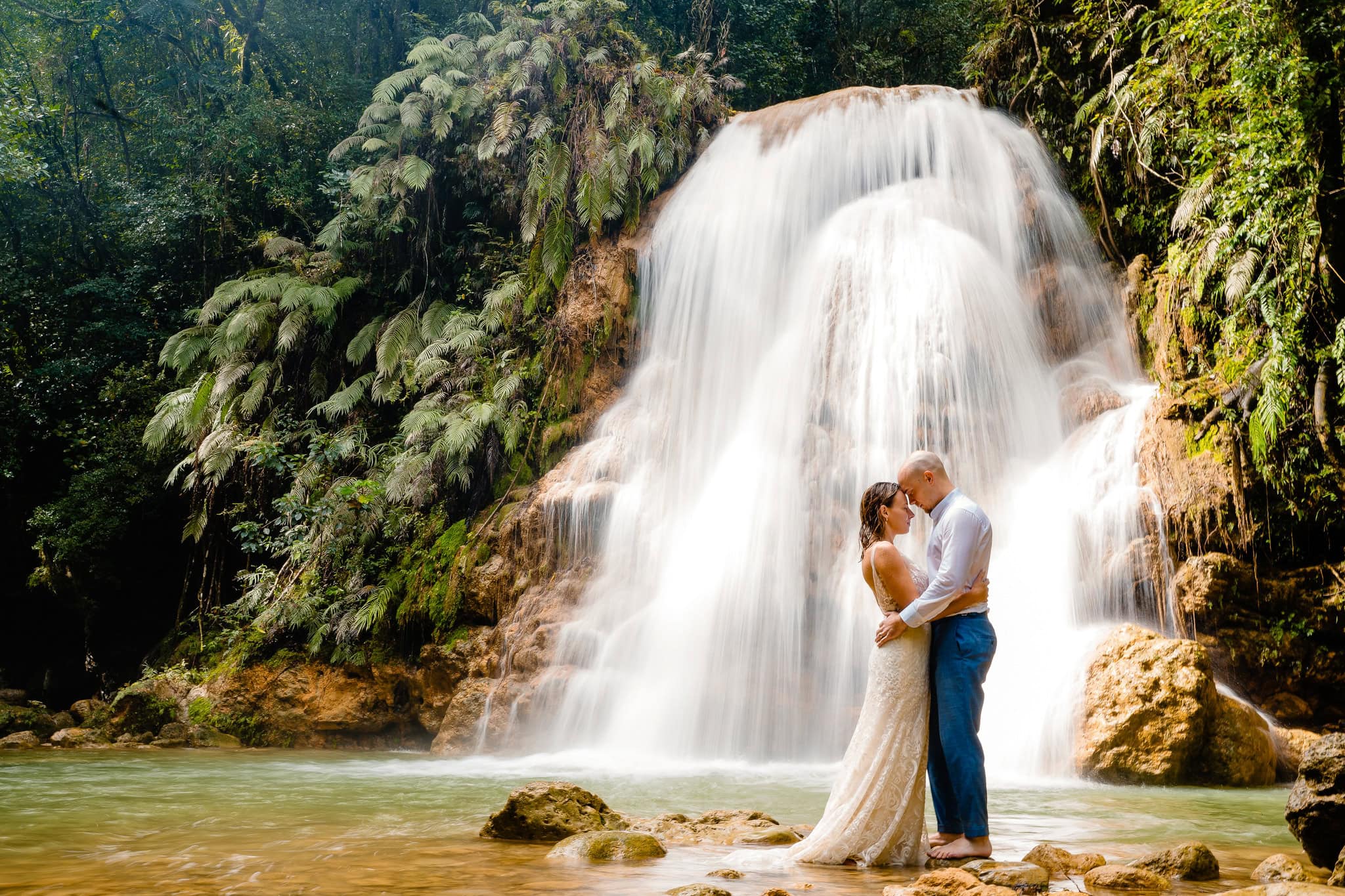 Bride and groom kissing at the foot of El Limon waterfall on the Samana peninsula, Dominican Republic