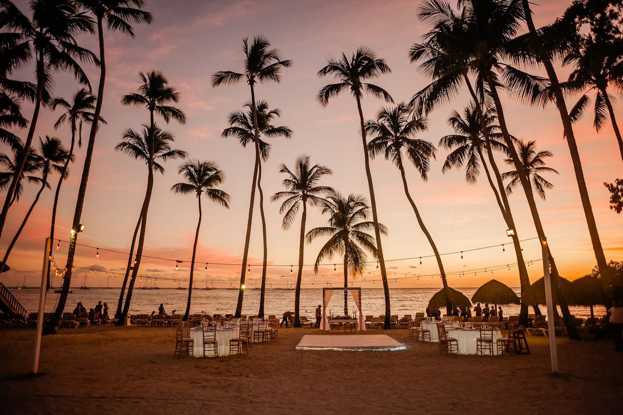 Beach ceremony set up under the palms at sunset at Secrets and Dreams La Romana in Bayahibe, Dominican Republic