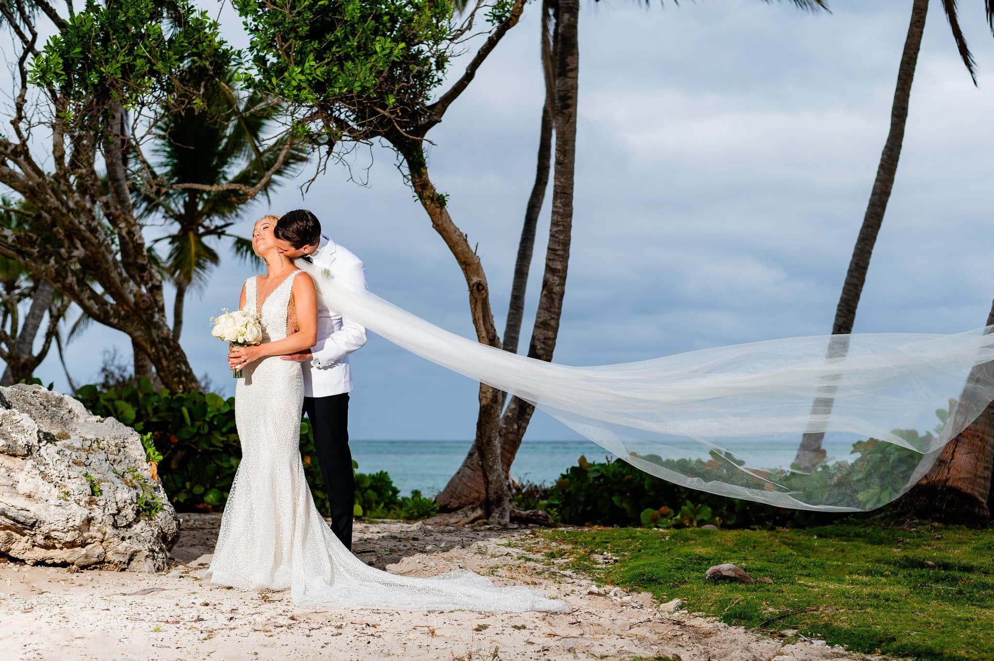 Bride veil catching the wind on a Punta Cana beach during a wedding portrait session